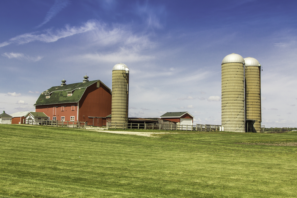 American,country,farm,with,silos,against,blue,sky